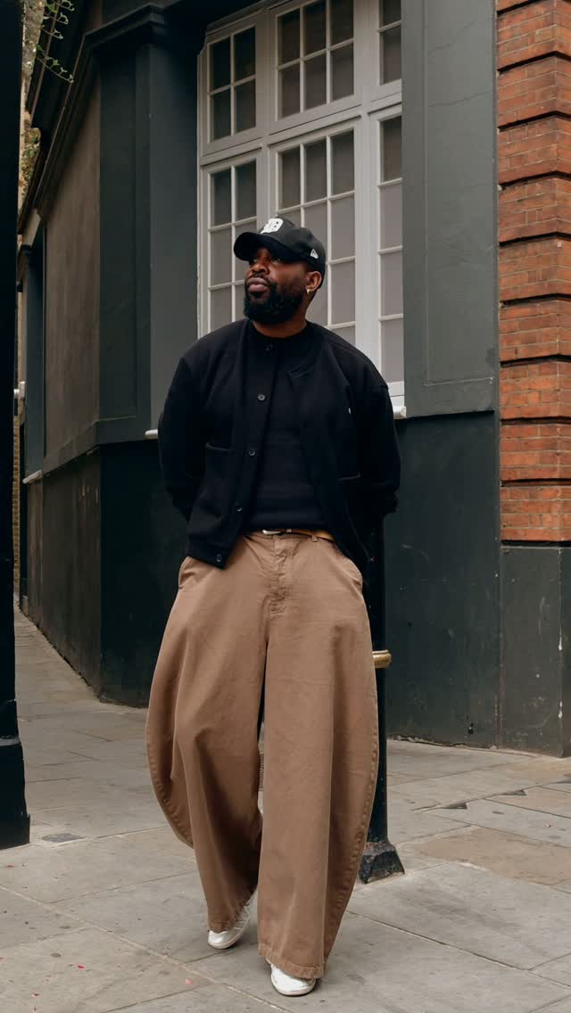Man wearing a clearly visible black jacket with tan trousers